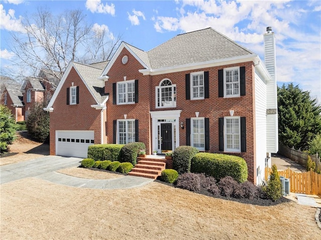 view of front of house featuring driveway, a chimney, fence, and brick siding