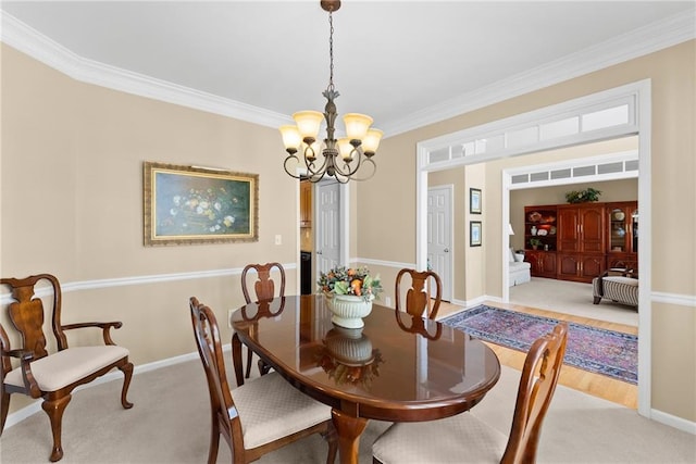 dining room with crown molding, light colored carpet, a notable chandelier, and baseboards