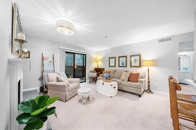 living room featuring visible vents, carpet floors, baseboards, and a fireplace