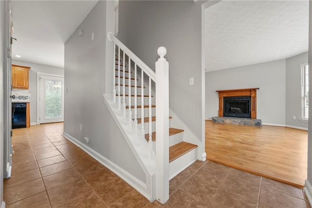 staircase with a fireplace and wood-type flooring