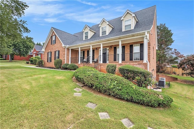 cape cod home with central AC unit, covered porch, and a front yard