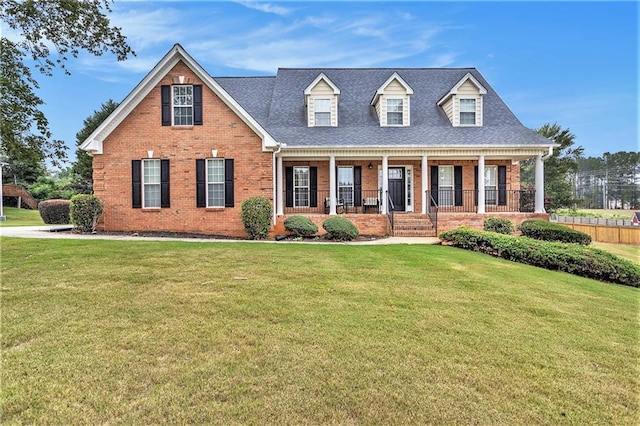 cape cod home featuring a front lawn and covered porch