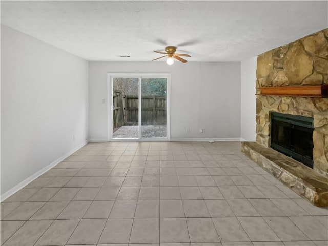 unfurnished living room with ceiling fan, light tile patterned flooring, and a fireplace