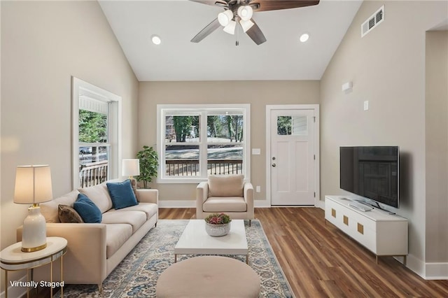 living room with baseboards, visible vents, and wood finished floors