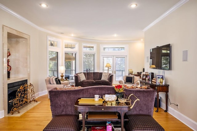 living room with a wealth of natural light, light hardwood / wood-style flooring, and ornamental molding