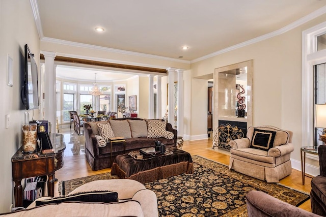 living room featuring ornamental molding, decorative columns, and light hardwood / wood-style floors