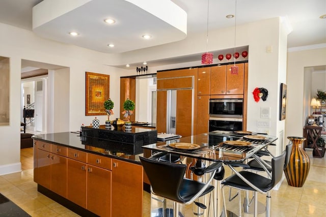 kitchen featuring a kitchen island, dark stone counters, wall oven, and light tile patterned flooring