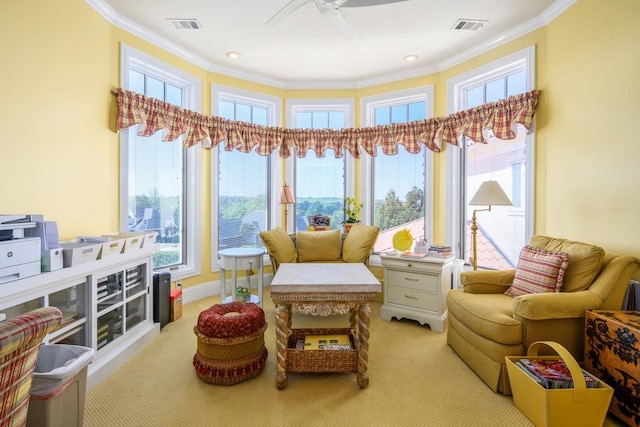 living area with ceiling fan, light carpet, and ornamental molding