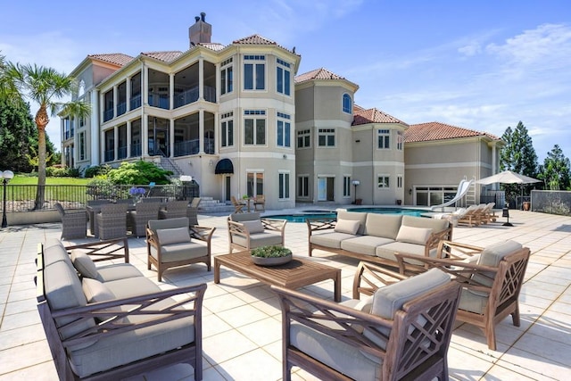 view of patio / terrace with a fenced in pool, an outdoor hangout area, and a balcony