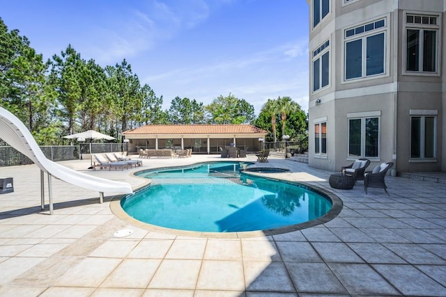 view of pool featuring a water slide and a patio area