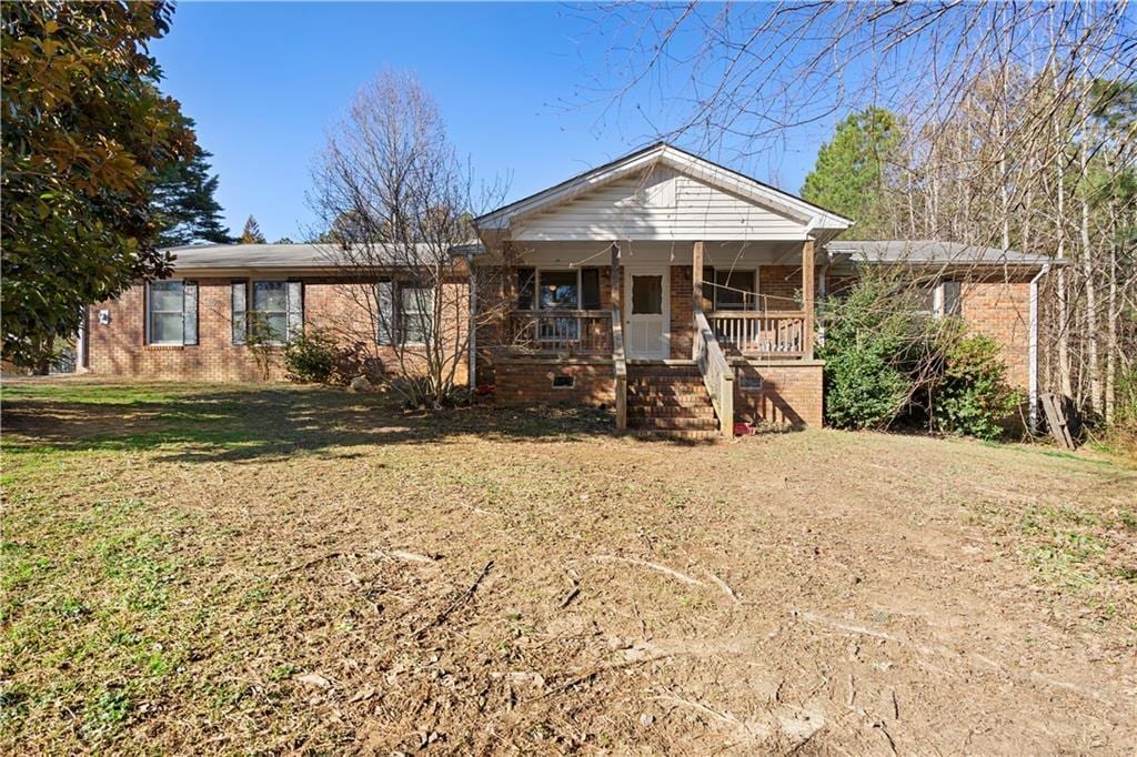 view of front facade featuring covered porch and a front yard