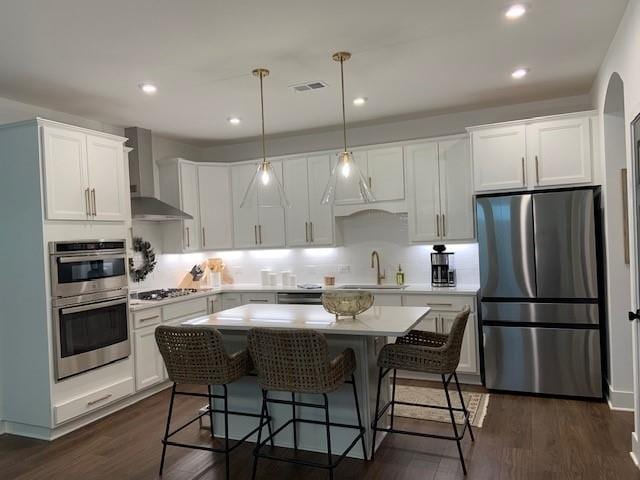 63 Aspen Way, Dallas, GA 30157 - kitchen featuring stainless steel appliances, wall chimney range hood, light countertops, white cabinetry, and recessed lighting