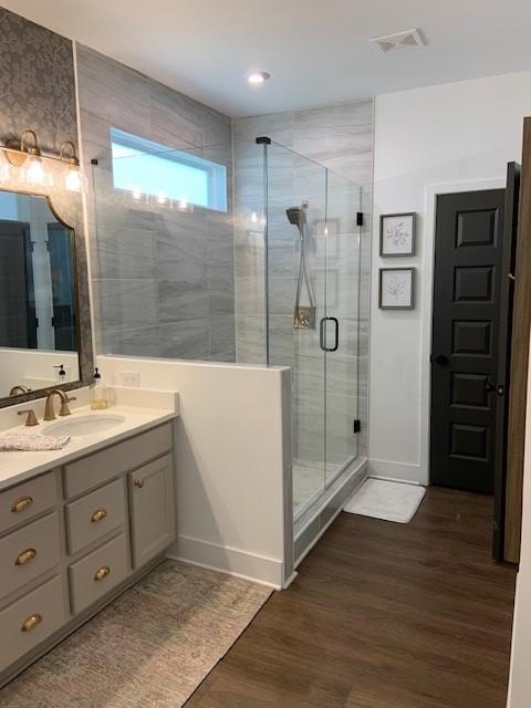 63 Aspen Way, Dallas, GA 30157 - bathroom featuring wood finished floors, a shower stall, vanity, and baseboards