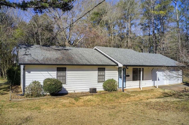 single story home with a garage, driveway, a shingled roof, and a front lawn