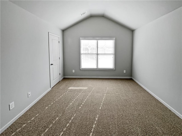 unfurnished room featuring lofted ceiling and carpet floors