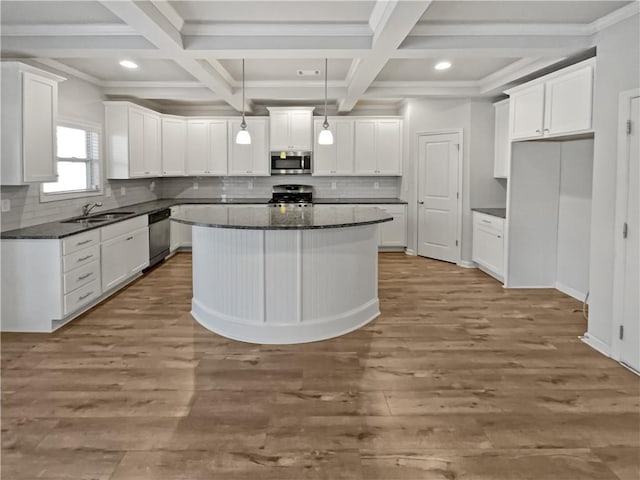 kitchen with a kitchen island, stainless steel appliances, white cabinets, and sink