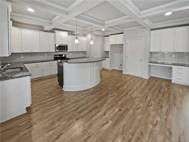 kitchen with coffered ceiling, white cabinets, pendant lighting, and appliances with stainless steel finishes