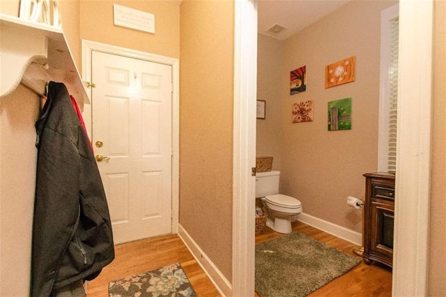 bathroom with wood-type flooring, toilet, and vanity