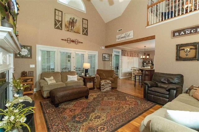 living room featuring hardwood / wood-style floors, a chandelier, and a high ceiling