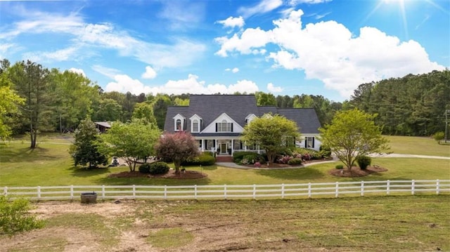 new england style home with a front yard and a rural view