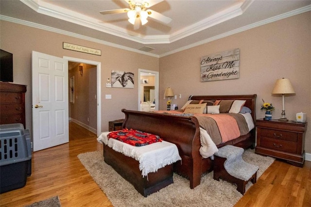 bedroom featuring ceiling fan, ornamental molding, and a raised ceiling