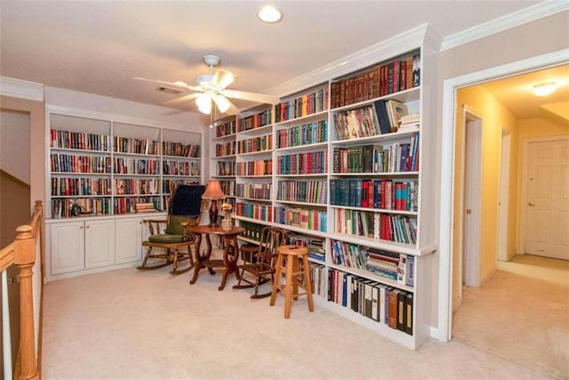 sitting room featuring ceiling fan, light colored carpet, and crown molding