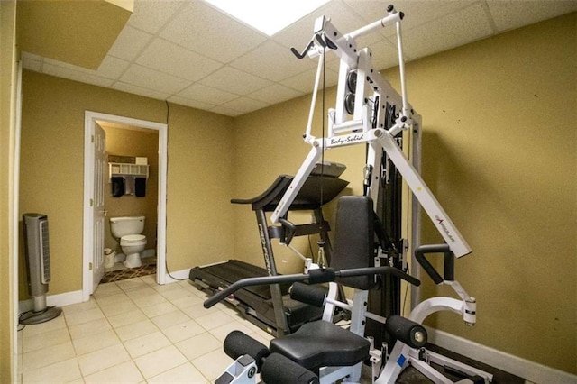 workout room featuring a drop ceiling and light tile patterned floors