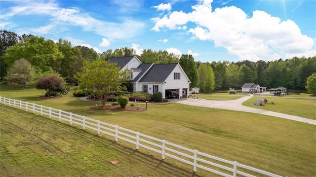 view of front of property featuring a front lawn, a rural view, and a garage