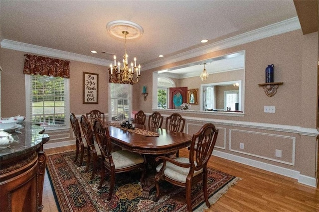 dining room with crown molding, an inviting chandelier, and hardwood / wood-style flooring