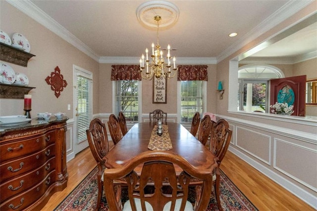 dining area featuring light wood-type flooring, a chandelier, and ornamental molding