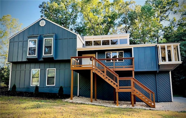 rear view of house with a deck and a lawn