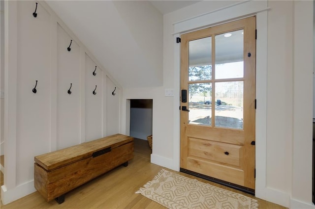 mudroom featuring light wood-style floors, baseboards, and vaulted ceiling