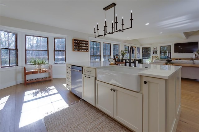 kitchen featuring recessed lighting, light countertops, stainless steel dishwasher, light wood-style floors, and a sink