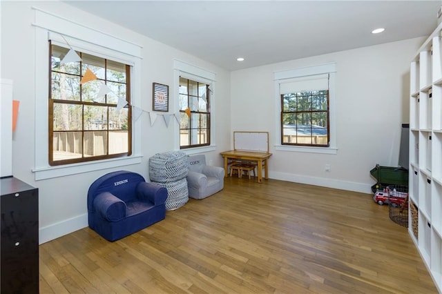 living area featuring recessed lighting, a healthy amount of sunlight, baseboards, and wood finished floors