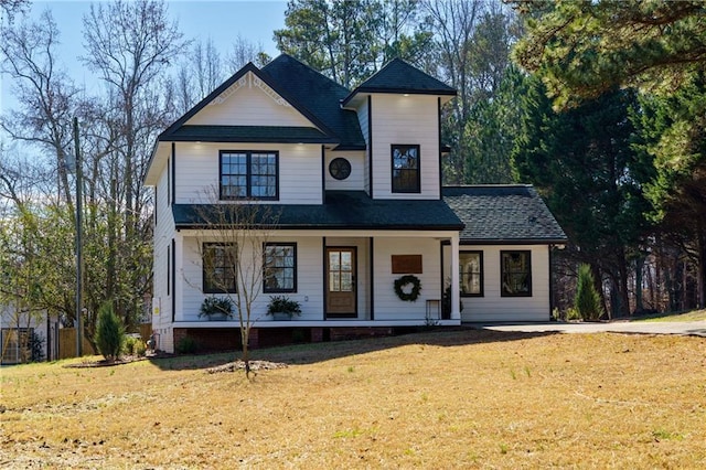 modern farmhouse featuring covered porch and a front yard