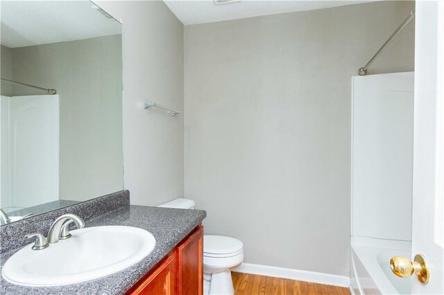 2384 Coach Way, Jonesboro, GA 30236 - bathroom with wood finished floors, baseboards, toilet, shower / washtub combination, and vanity