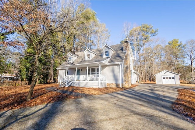 cape cod house with an outbuilding, a garage, and covered porch