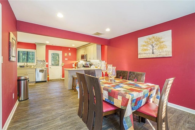 dining room with dark hardwood / wood-style floors and sink