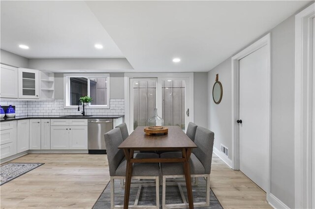 dining space with light hardwood / wood-style flooring and sink