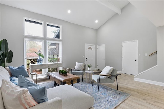 living room featuring beam ceiling, high vaulted ceiling, and light hardwood / wood-style flooring