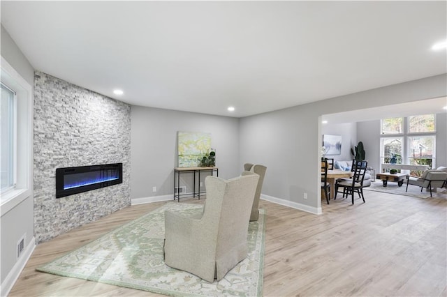 living room with light wood-type flooring and a fireplace