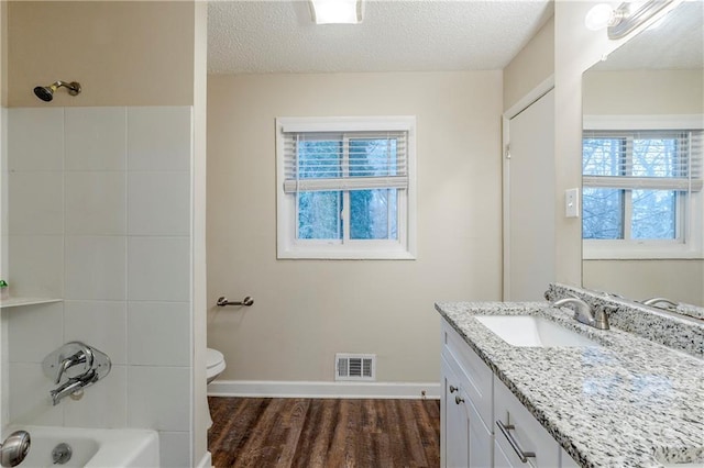 full bathroom with vanity, wood finished floors, visible vents, and a textured ceiling