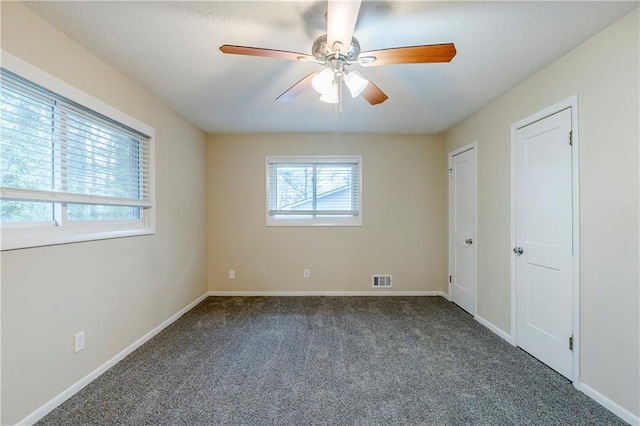 unfurnished bedroom with visible vents, ceiling fan, baseboards, carpet, and a textured ceiling