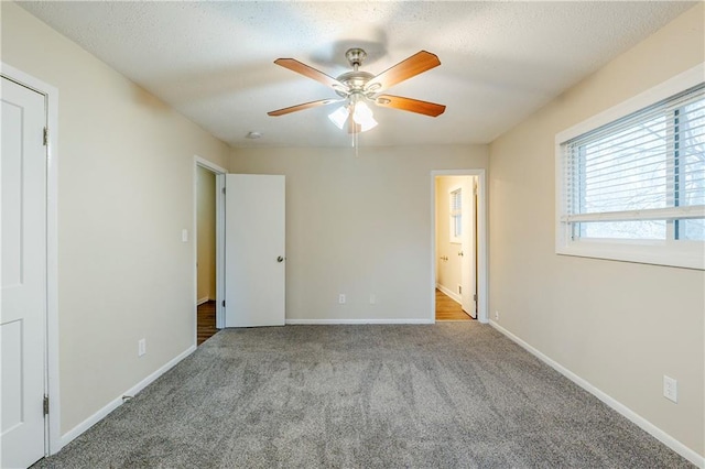 unfurnished bedroom featuring carpet flooring, baseboards, connected bathroom, and a textured ceiling