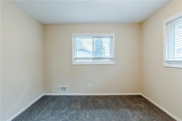 unfurnished room with visible vents, baseboards, and carpet