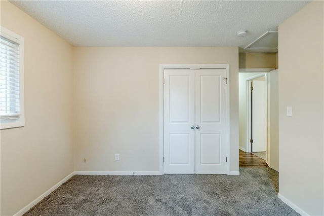 unfurnished bedroom with carpet flooring, a closet, and a textured ceiling