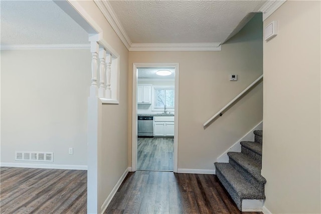 foyer with wood finished floors, visible vents, ornamental molding, stairs, and a textured ceiling