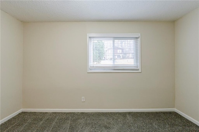 spare room featuring carpet, baseboards, and a textured ceiling