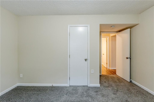 unfurnished bedroom featuring baseboards, a textured ceiling, and carpet flooring