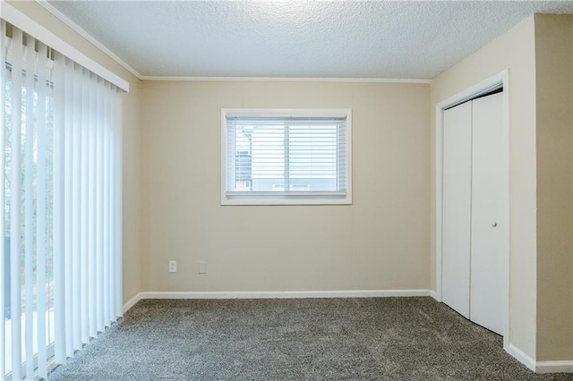 unfurnished bedroom with a closet, carpet floors, a textured ceiling, and baseboards